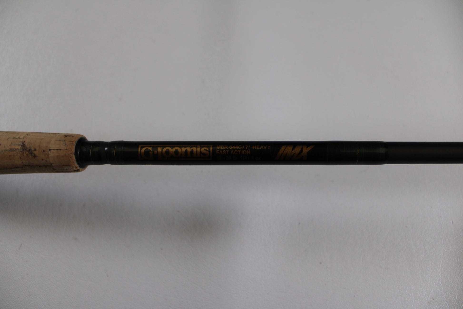 A close-up of the G. Loomis MBR844c IMX 7'0" Heavy Used Casting Rod in good condition, featuring a cork handle—ideal for those seeking value or trading up through our Rod and Reel Trade-In Program for store credit.