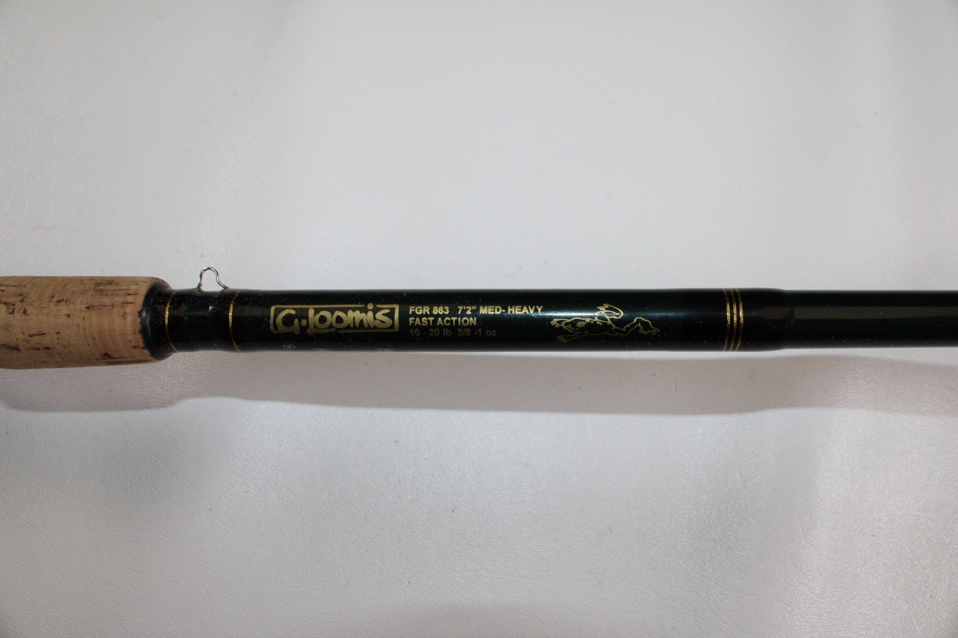 A close-up of a G. Loomis FGR863 7'2" Medium Heavy Used Casting Rod in good condition, featuring a cork handle and fast action—ideal for quality gear seekers or those interested in our rod and reel trade-in program.