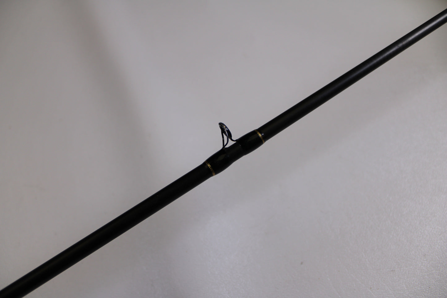 A close-up of the Falcon Cara T7 CC-5-167S Weightless Worm Used Casting Rod in Good Condition with a line guide—ideal for upgrading your gear and earning store credit through our Rod and Reel Trade-In Program.