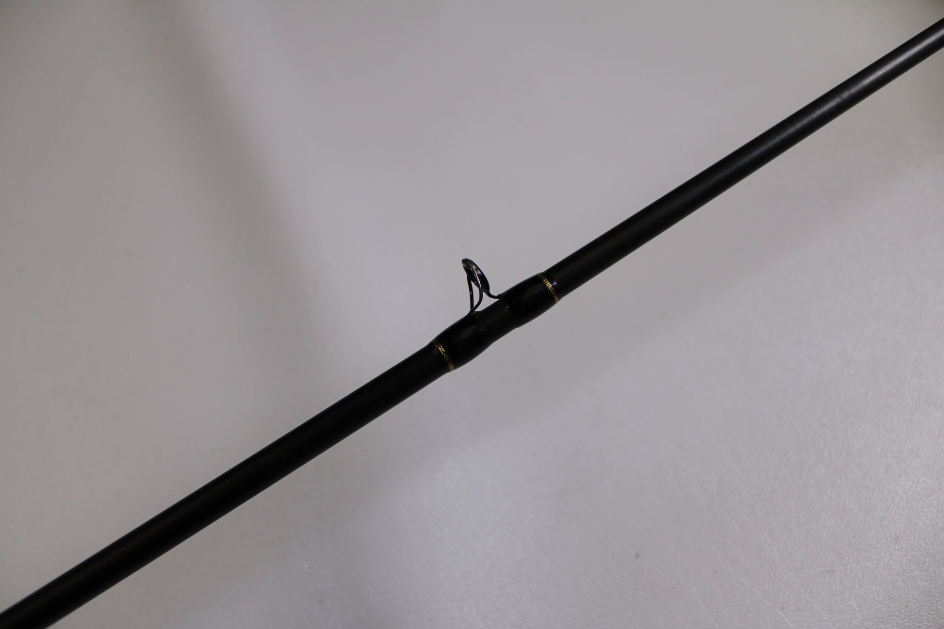 A close-up of the Falcon Cara T7 CC-5-167S Weightless Worm Used Casting Rod in Good Condition with a line guide—ideal for upgrading your gear and earning store credit through our Rod and Reel Trade-In Program.