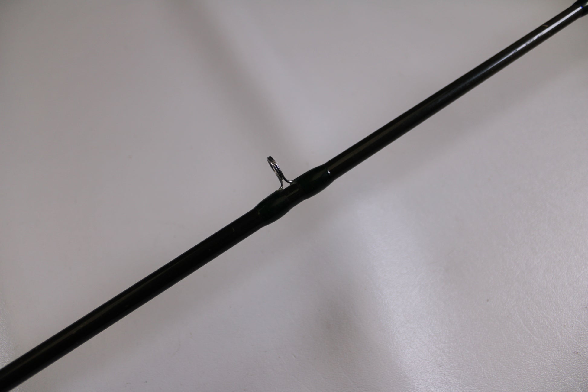A close-up of the G. Loomis BCFR894 GLX, a used casting rod in good condition, features a single metal line guide against a plain white background—ideal for anglers interested in our rod and reel trade-in program.
