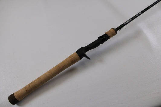 A close-up of the G. Loomis IMX-PRO 782c MBR 6'6" Medium Used Casting Rod in excellent condition, highlighting its cork handle and black reel seat—ideal for assessing used gear or our rod and reel trade-in program.