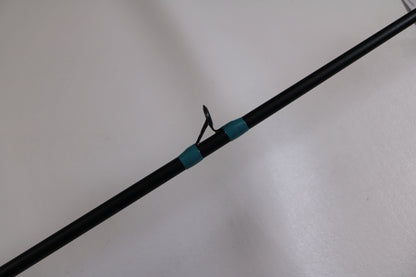 A close-up of the G. Loomis NRX+ 781c Inshore 6'6" Med-Lite Used Casting Rod in excellent condition, featuring a metal guide ring and teal thread wraps—ideal for our Rod and Reel Trade-In Program or upgrading your gear.