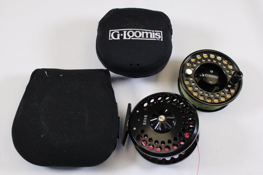 Two G. Loomis GL 8-9-10 fly reels with spare spool in excellent used condition are shown next to their branded black cases—ideal gear for our Rod and Reel Trade-In Program.