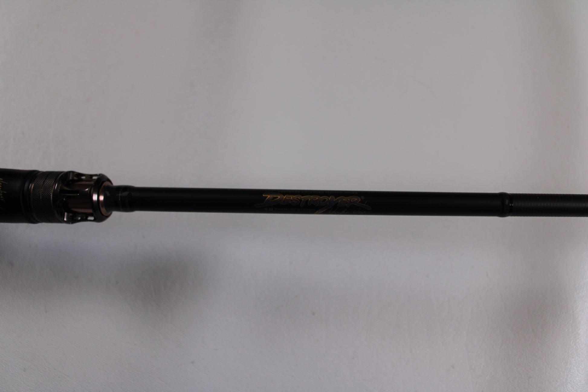 A close-up of the Megabass Destroyer P5 F4-66X Used Casting Rod in excellent condition, featuring gold “Destroyer” lettering on a black shaft—perfect for those exploring our Rod and Reel Trade-In Program or quality used gear.
