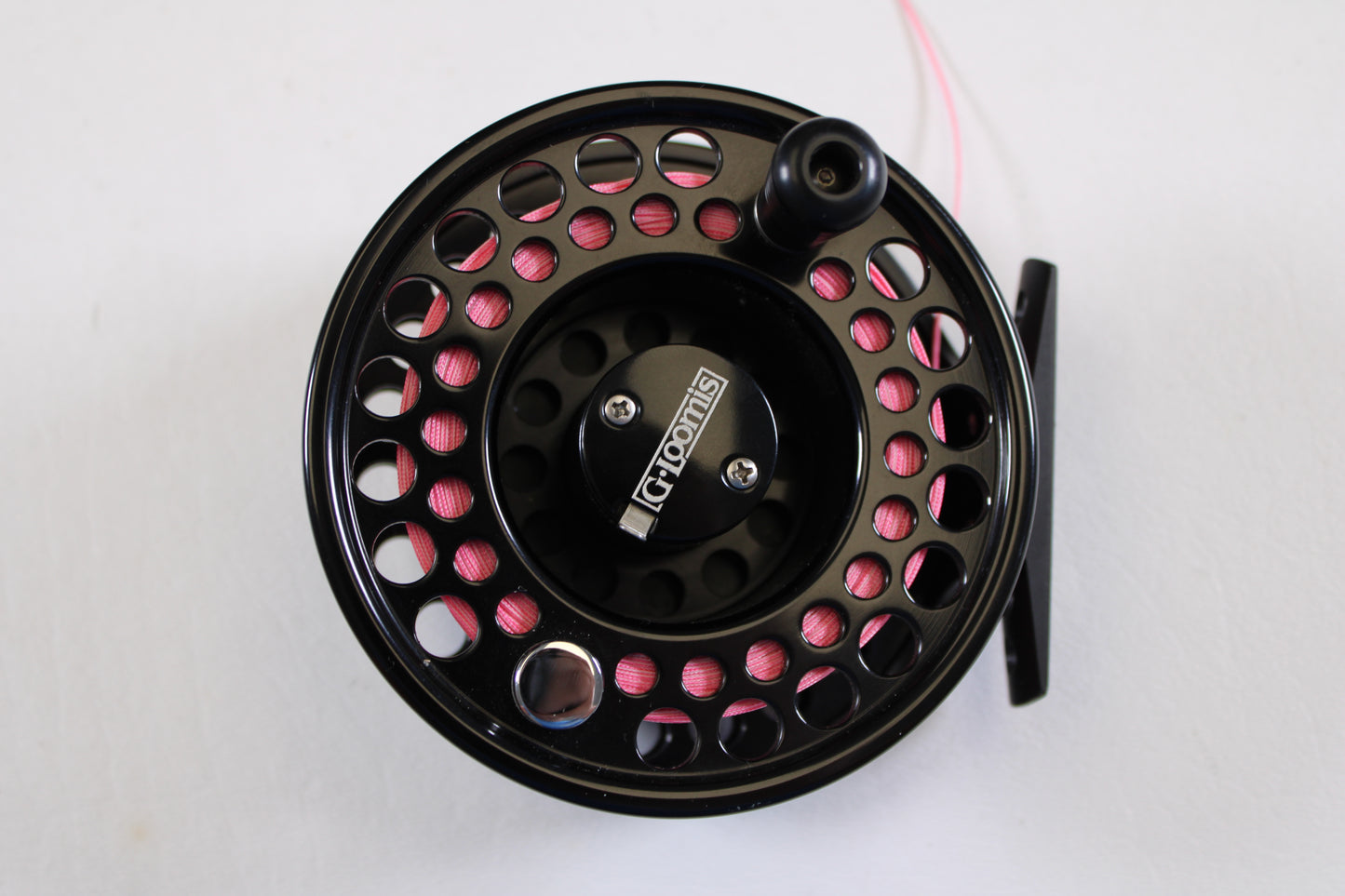 A close-up of the G. Loomis GL 8-9-10 with Spare Spool—Used Fly Reel in excellent condition, wound with pink line on a white background, ideal for upgrade via our Rod and Reel Trade-In Program for store credit or used gear.