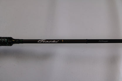 A close-up of the Megabass Orochi X10 F1.1/2-65XT Cliffhanger Used Casting Rod in excellent condition, featuring "Orochi" and "CHT Layer" on the shaft—ideal for used gear buyers or our Rod and Reel Trade-In program.