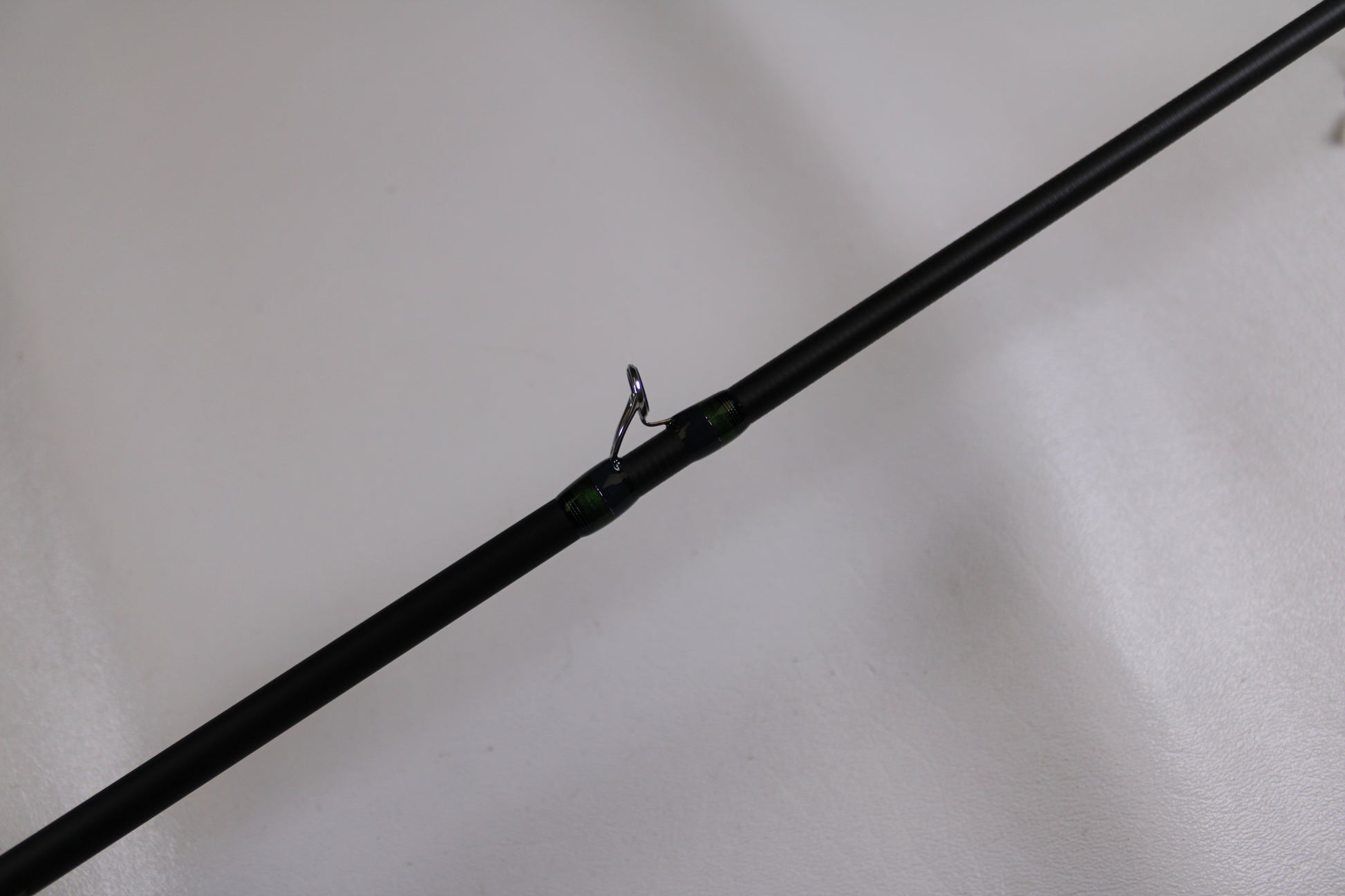 A close-up of the Megabass Orochi X10 F1.1/2-65XT Cliffhanger Used Casting Rod in excellent condition, highlighting a metal line guide—ideal for anglers looking to upgrade or trade in used Megabass gear for store credit.