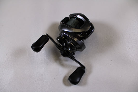 A Shimano Chronarch MGL CHMGL150XG used casting reel in good condition, with dual handles, from our used gear selection, shown on a plain white surface.