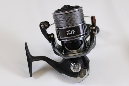 A close-up of the Daiwa BG MQ BGMQ6000D-H 5.7:1 Used Spinning Reel in excellent condition, black and silver with fishing line on the spool, photographed on a white background—ideal for our Rod and Reel Trade-In Program store credit.