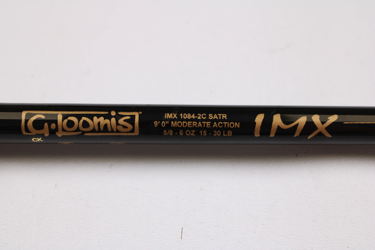 Close-up of a G. Loomis Salmon & Steelhead IMX 1084-2C SATR 9'0" Used Casting Rod in excellent condition, featuring gold text on black—ideal for anglers seeking upgrade options or used gear from G. Loomis.