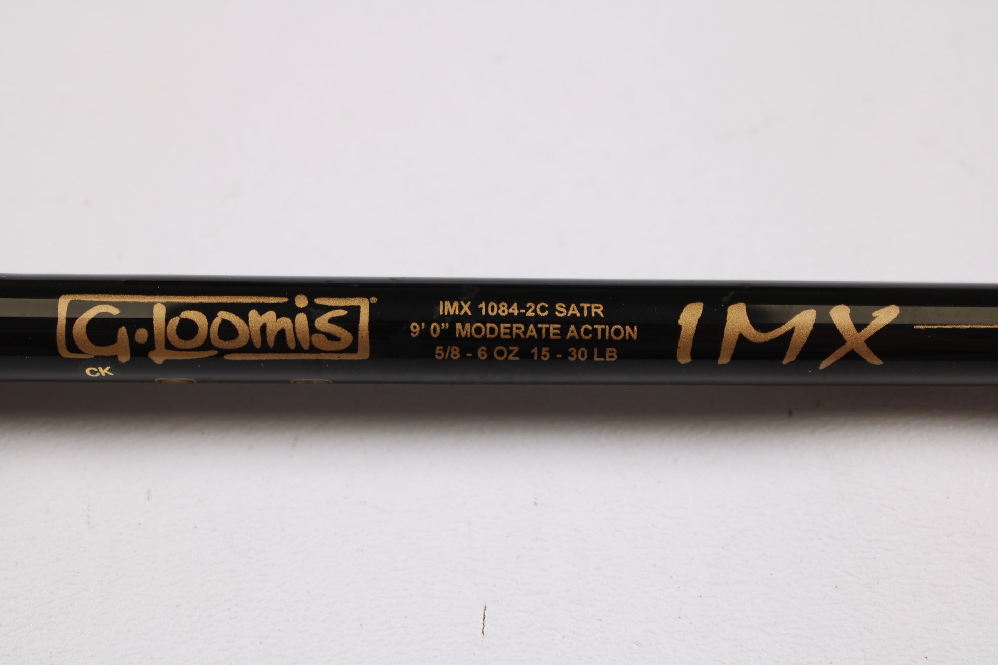 Close-up of a G. Loomis Salmon & Steelhead IMX 1084-2C SATR 9'0" Used Casting Rod in excellent condition, featuring gold text on black—ideal for anglers seeking upgrade options or used gear from G. Loomis.