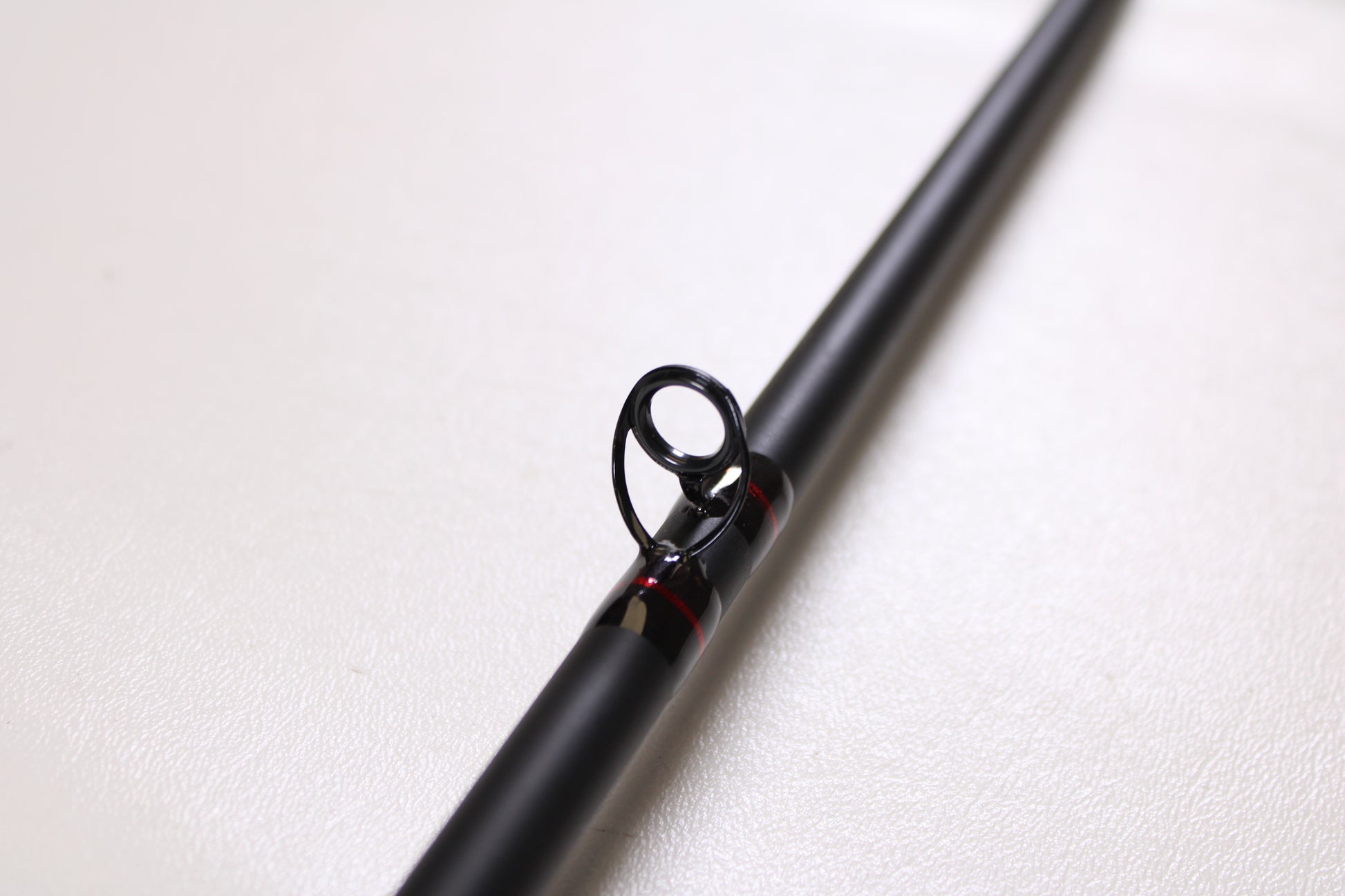 A close-up of the G. Loomis Salmon & Steelhead IMX 1084-2C SATR 9'0" Used Casting Rod in excellent condition, featuring a metal guide ring, is shown against a plain white background.