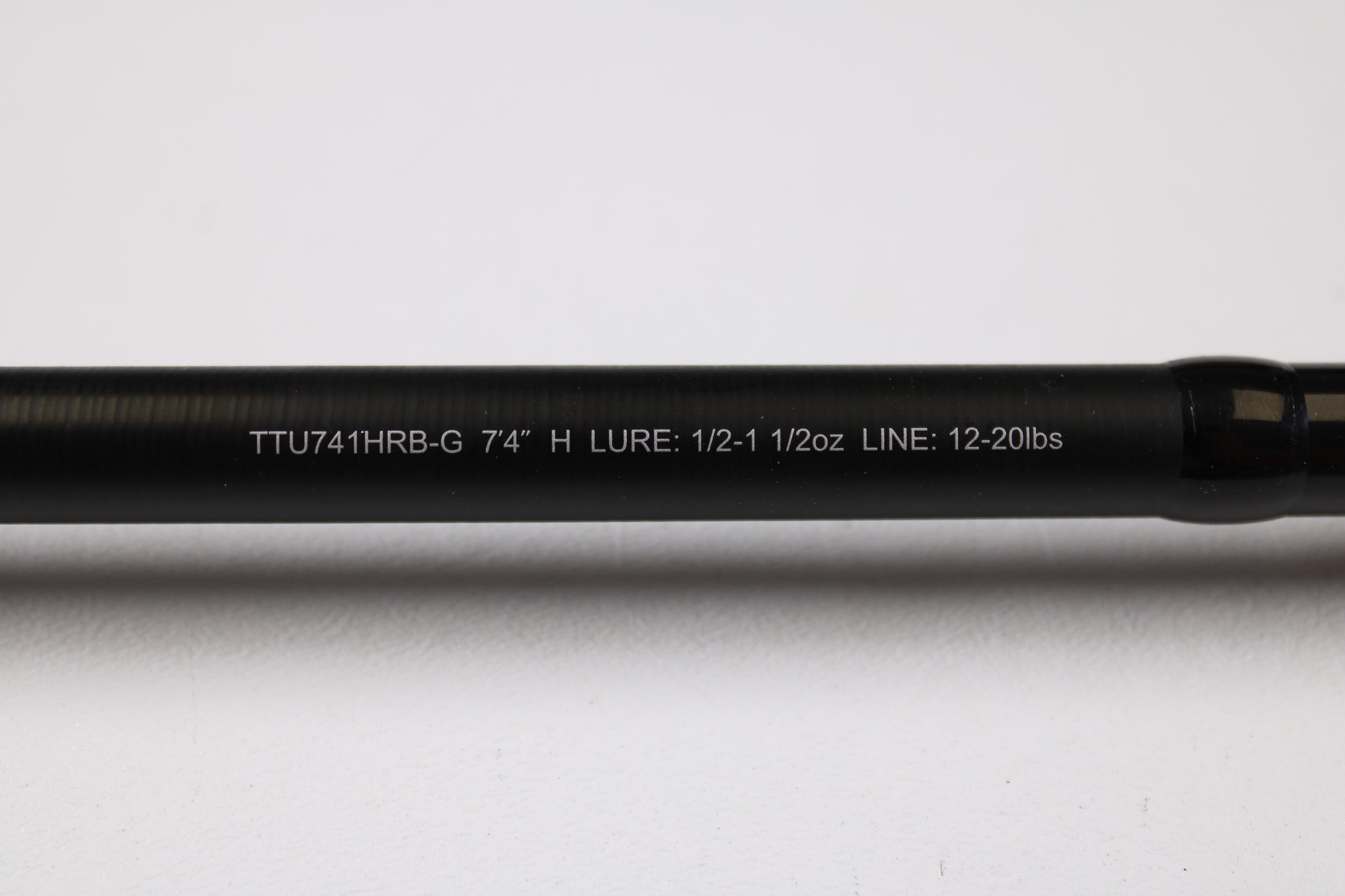 A close-up of the Daiwa Tatula TTU741HRB-G 7'4" Heavy Glass Used Casting Rod shows its specs in white text on a black rod, ideal for our Rod and Reel Trade-In Program if you're upgrading your used Daiwa gear.