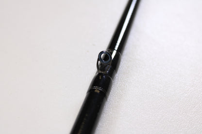 Close-up of a Daiwa Tatula TTU741HRB-G 7'4" Heavy Glass used casting rod in very good condition, featuring a single guide ring on a white surface—perfect for those interested in quality used gear or our Rod and Reel Trade-In Program.