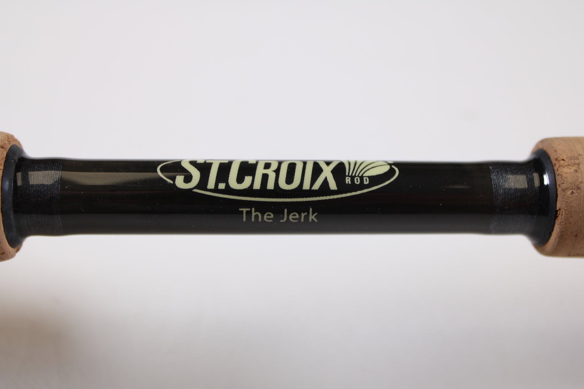 Close-up of the St. Croix Victory VTC68MXF "The Jerk" 6'8" Medium Used Casting Rod—very good condition, with logo and model name visible on the black rod between two cork handles—eligible for our Rod and Reel Trade-In Program.