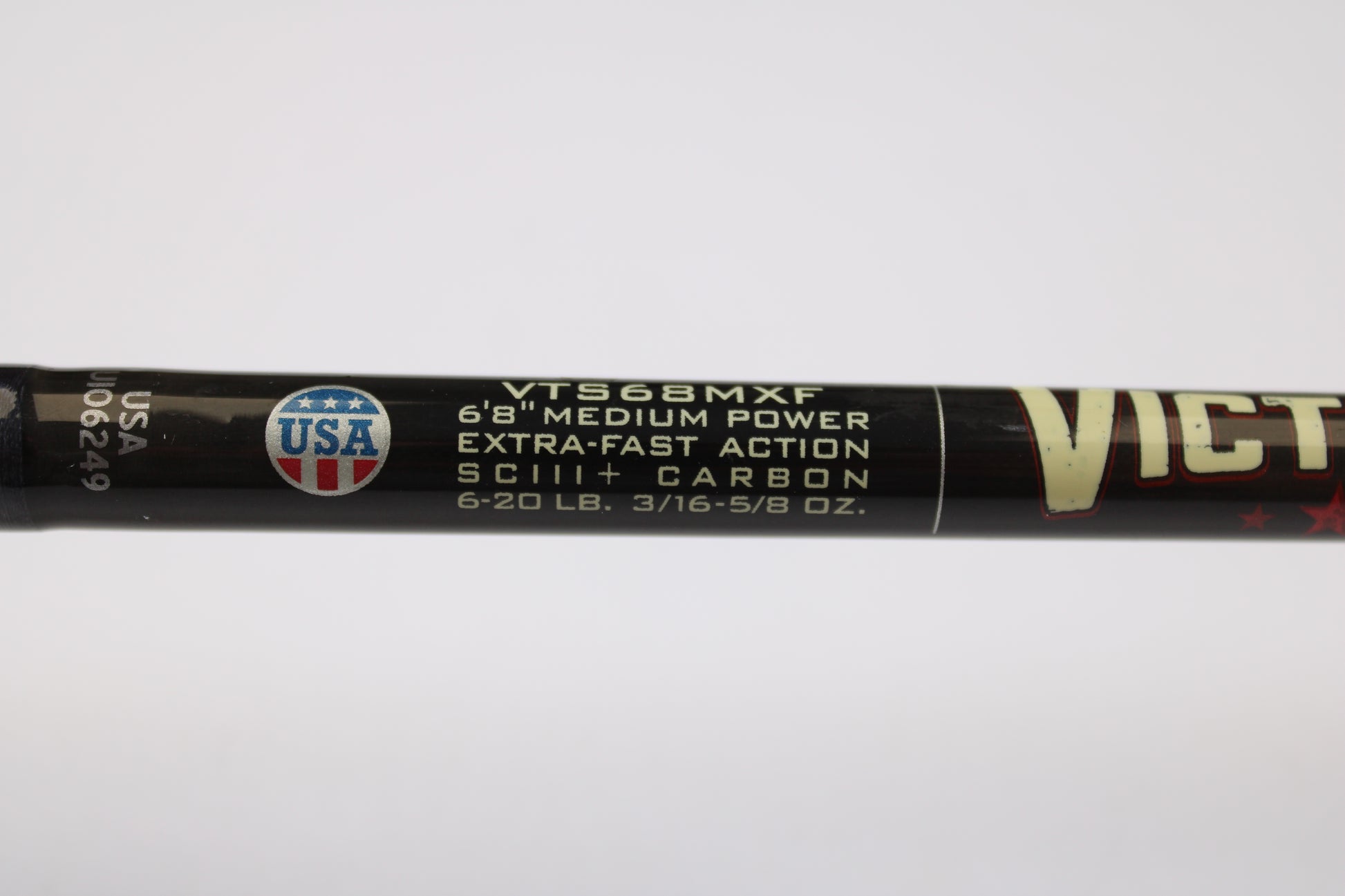 Close-up of St. Croix Victory VTS68MXF Tactical 6'8" Medium Spinning Rod label: extra-fast action, SCIII+ carbon, 6-20 lb line, 3/16-5/8 oz lure weight. USA emblem at left—eligible for our Trade-In Program for store credit on used gear.