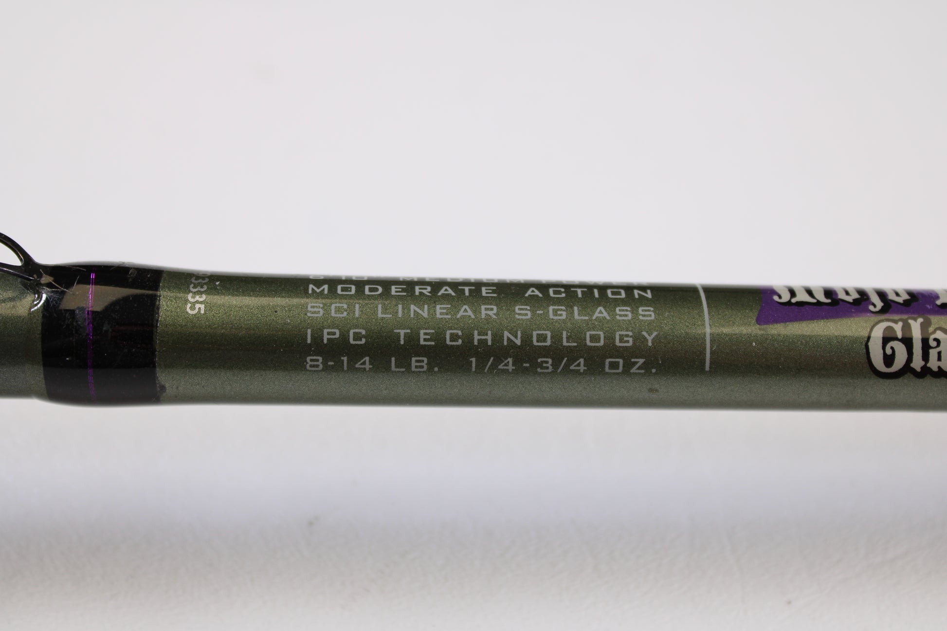Close-up of a St. Croix Mojo Bass MGC610MM Target Cranker 6'10" Medium Used Casting Rod in excellent condition, showing "MODERATE ACTION, SCII LINEAR S-GLASS, IPC TECHNOLOGY, 8-14 LB., 1/4-3/4 OZ." on olive green rod.