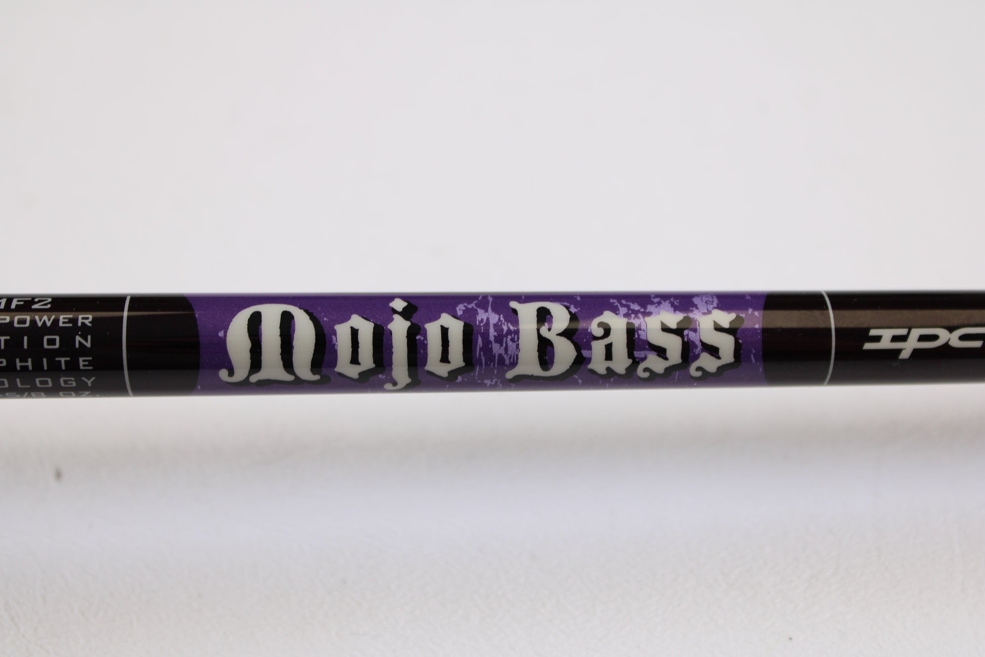 A close-up of a St. Croix Mojo Bass MJC71MF2 7'1" Medium Used Casting Rod in excellent condition, labeled in bold white letters on a purple background. Eligible for trade-in credit through the Rod and Reel Trade-In Program.