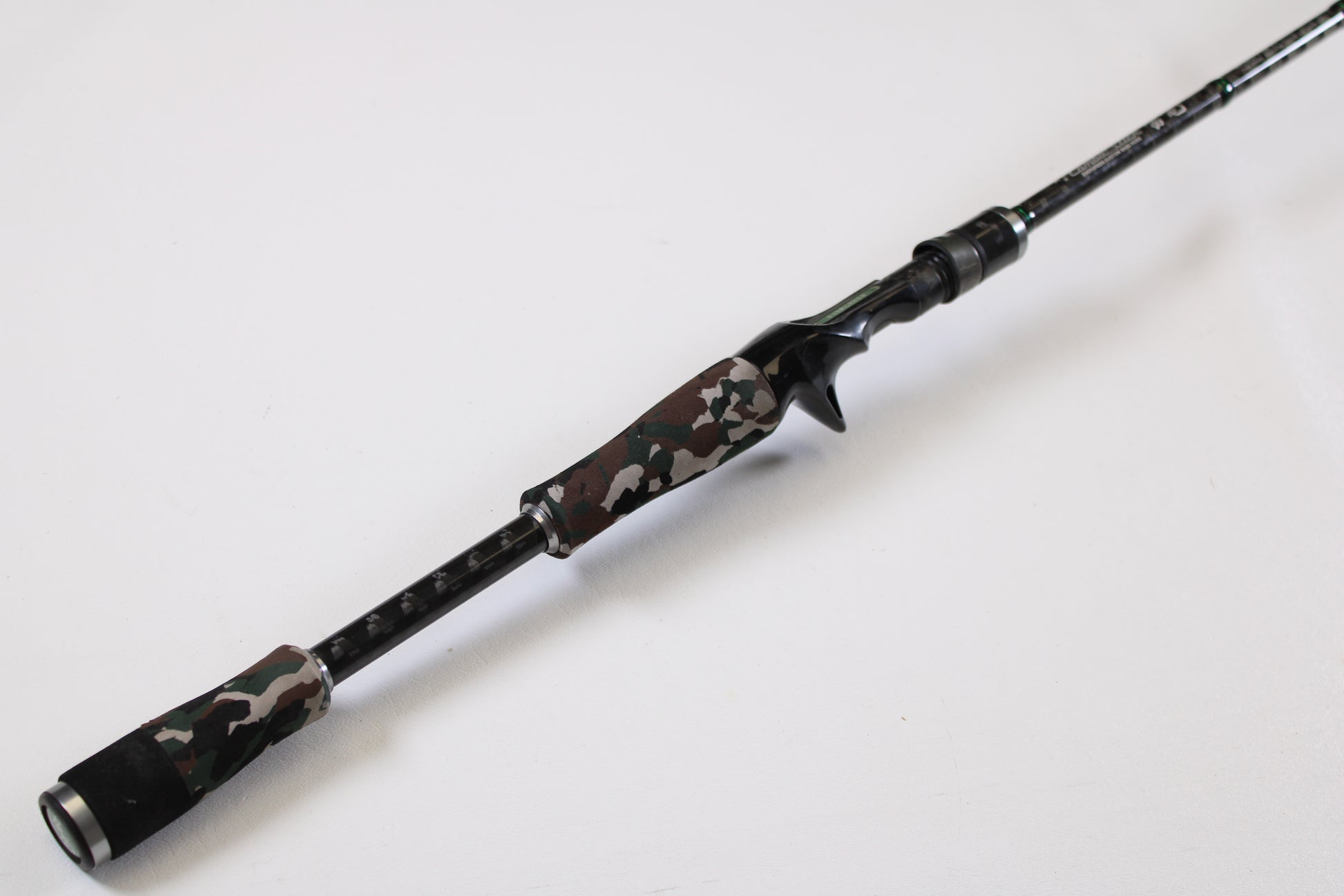 The Evergreen International Combat Stick RCSC-71M Jerkbait & Squarebill 7'1" Medium Used Casting Rod, in very good condition, features a camouflage-patterned handle and black accents. Trade in your old gear for store credit toward this modern rod.