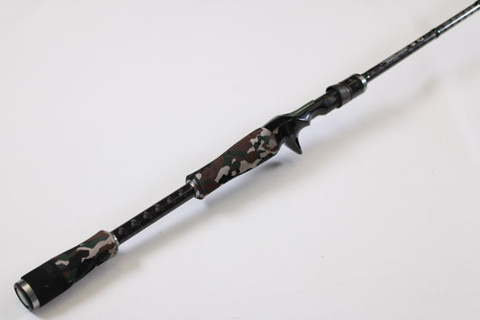 The Evergreen International Combat Stick RCSC-71M Jerkbait & Squarebill 7'1" Medium Used Casting Rod, in very good condition, features a camouflage-patterned handle and black accents. Trade in your old gear for store credit toward this modern rod.