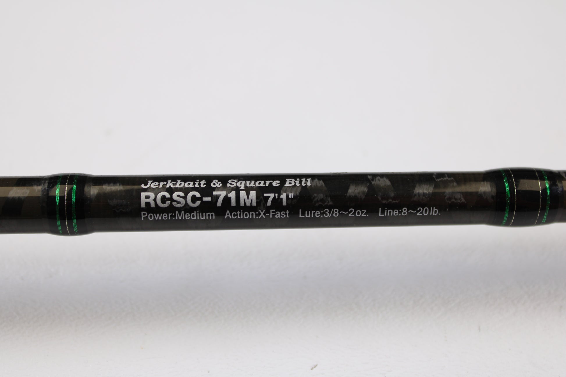 A close-up of the Evergreen Combat Stick RCSC-71M Jerkbait & Squarebill 7'1" Medium Used Casting Rod—ideal for our Rod and Reel Trade-In Program—shows its sleek black design, green accents, and white model text; condition is very good.