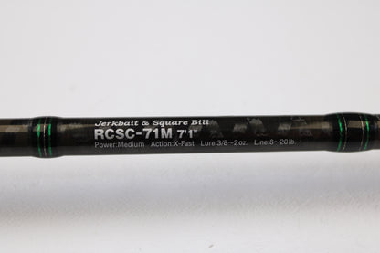 A close-up of the Evergreen Combat Stick RCSC-71M Jerkbait & Squarebill 7'1" Medium Used Casting Rod—ideal for our Rod and Reel Trade-In Program—shows its sleek black design, green accents, and white model text; condition is very good.
