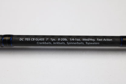 A close-up of the Dobyns Champion XP DC705CBGLASS 7'0" Medium Heavy Glass Casting Rod (Used, Excellent Condition) shows specs in white on black—trade up with our Rod and Reel Trade-In Program for store credit on your next Dobyns purchase.