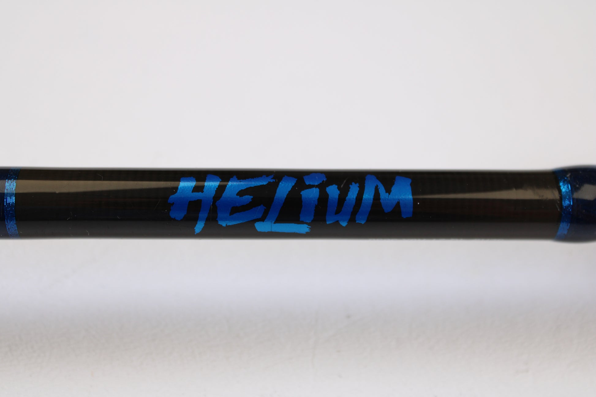 A close-up of a Kistler Helium HE703LMH 7'0" Lite Medium Heavy Used Casting Rod in excellent condition, featuring bold blue "HELIUM" graphics and blue bands—ideal for upgrading via our Rod & Reel Trade-In Program for store credit.
