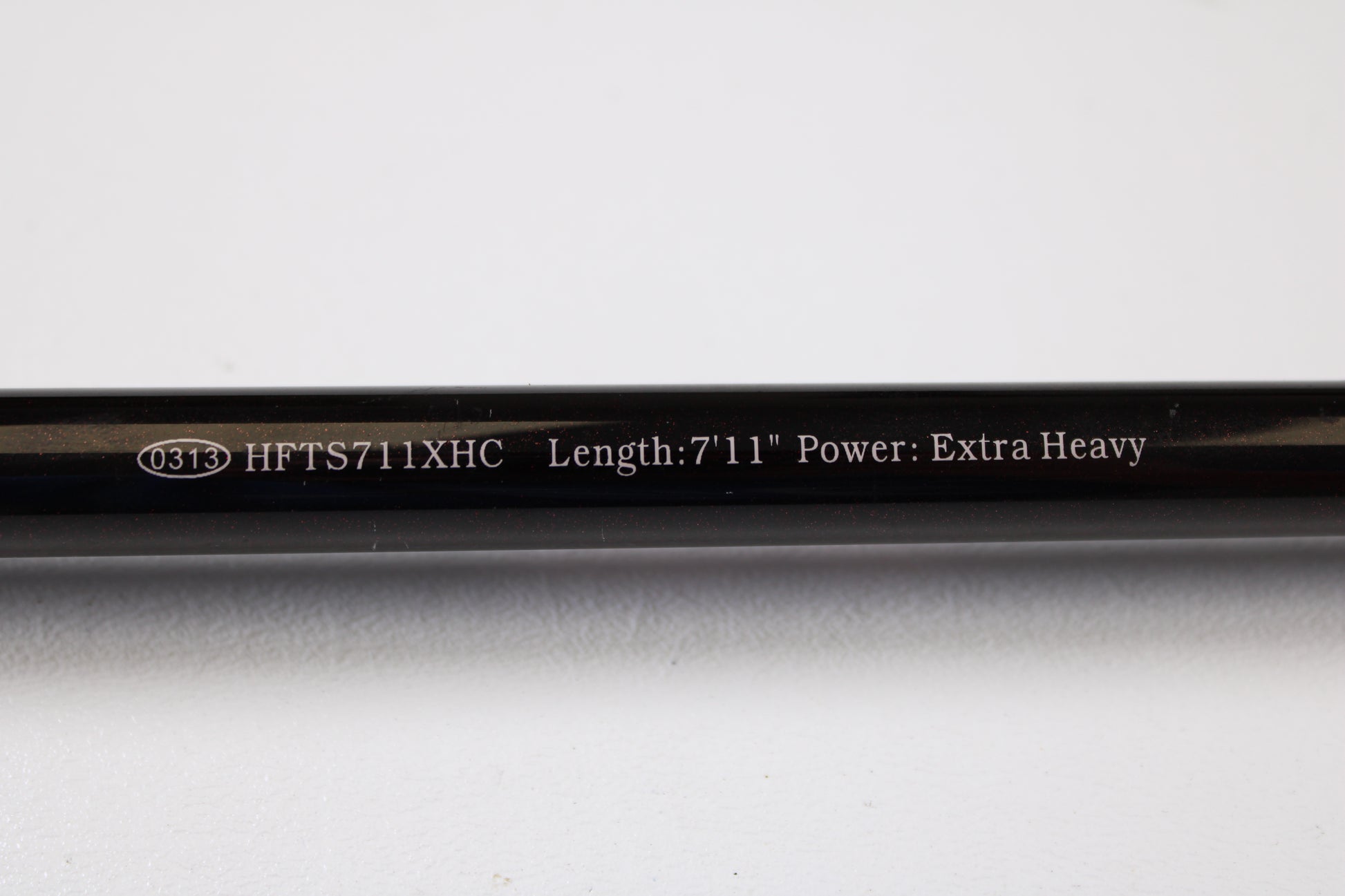 A close-up of the Halo Twilite HFTS711XHC 7'11" Extra Heavy Used Casting Rod in excellent condition shows white text on a black rod and an oval marked 0313—ideal for our rod and reel trade-in program.