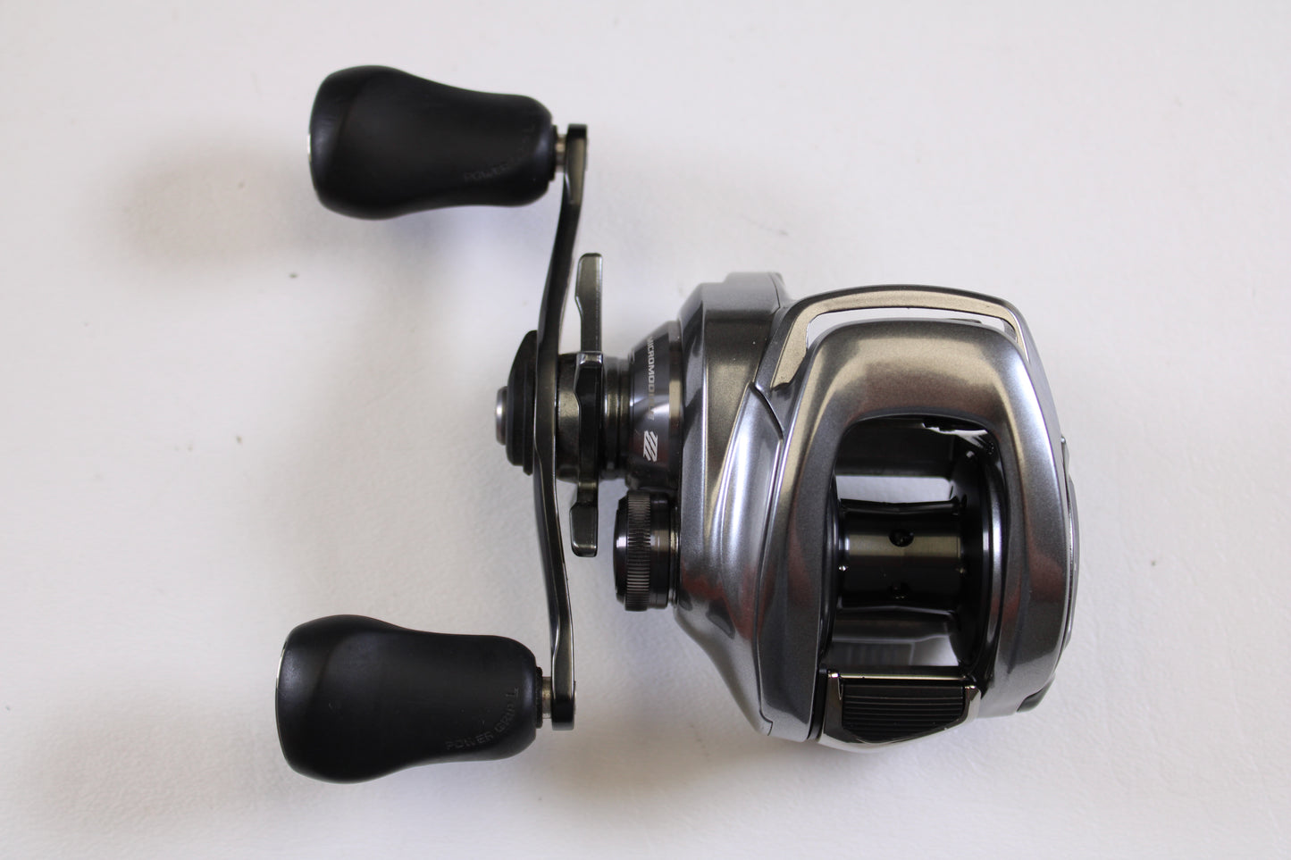 The used Shimano Bantam MGL BANTAMMGL151XG 8.1:1 LH Casting Reel in excellent condition features two black handles and is eligible for our Rod and Reel Trade-In Program—trade it in for store credit and upgrade today!.