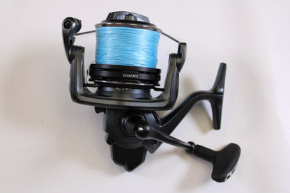 A Shimano Ultegra CI4+ ULTCI45500XTC 5.3:1 used spinning reel in excellent condition, with a black finish and bright blue line, is shown on a white background—ideal for your next upgrade or trade-in for store credit.