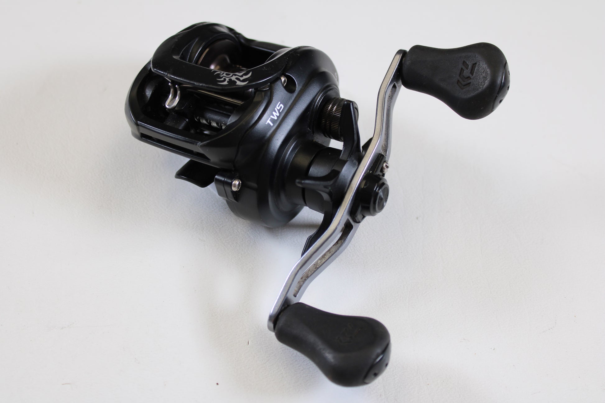 A close-up of the Daiwa Tatula 150 TAT150HSL 7.3:1 LH Used Casting Reel in good condition, featuring two ergonomic handles—ideal for upgrading through our Rod and Reel Trade-In Program or earning store credit on used Daiwa gear.