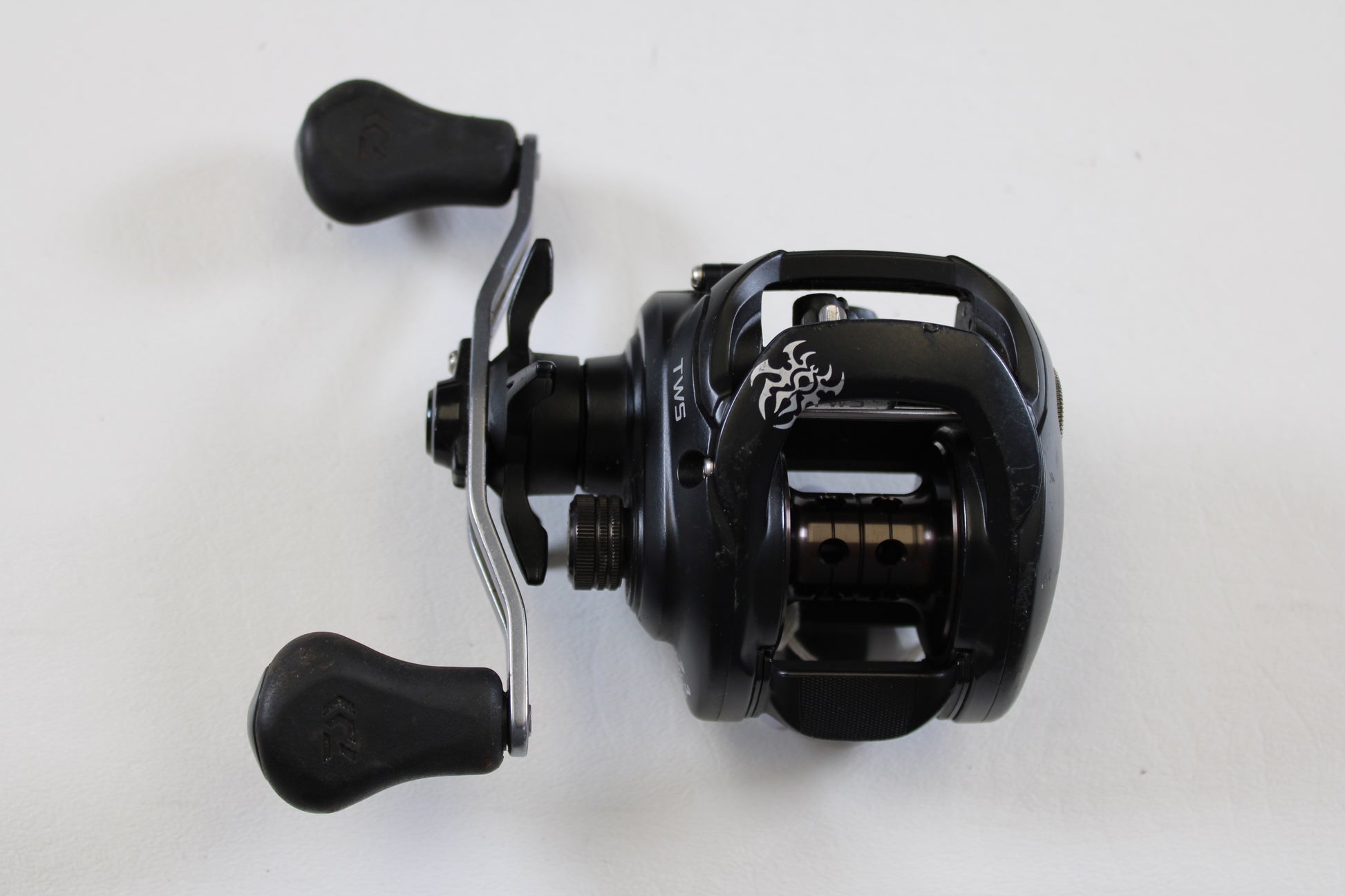 A Daiwa Tatula 150 TAT150HSL 7.3:1 LH casting reel in good used condition is shown against a plain white background—ideal for our Rod and Reel Trade-In Program or store credit on used gear.