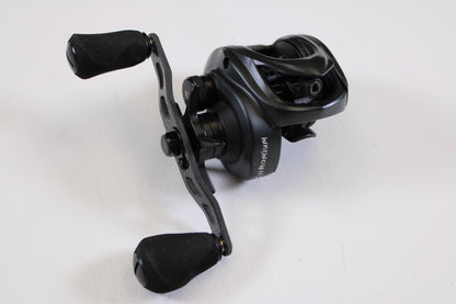A Kistler Chromium KCR-BK-R173 7.3:1 RH used casting reel in excellent condition, featuring two rubberized handles and stylish metallic and matte black finishes, is shown on a white surface—ideal for savings with our Rod and Reel Trade-In Program.