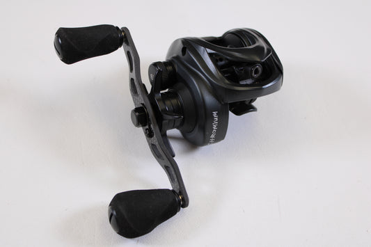 A Kistler Chromium KCR-BK-R173 7.3:1 RH used casting reel in excellent condition, featuring two rubberized handles and stylish metallic and matte black finishes, is shown on a white surface—ideal for savings with our Rod and Reel Trade-In Program.