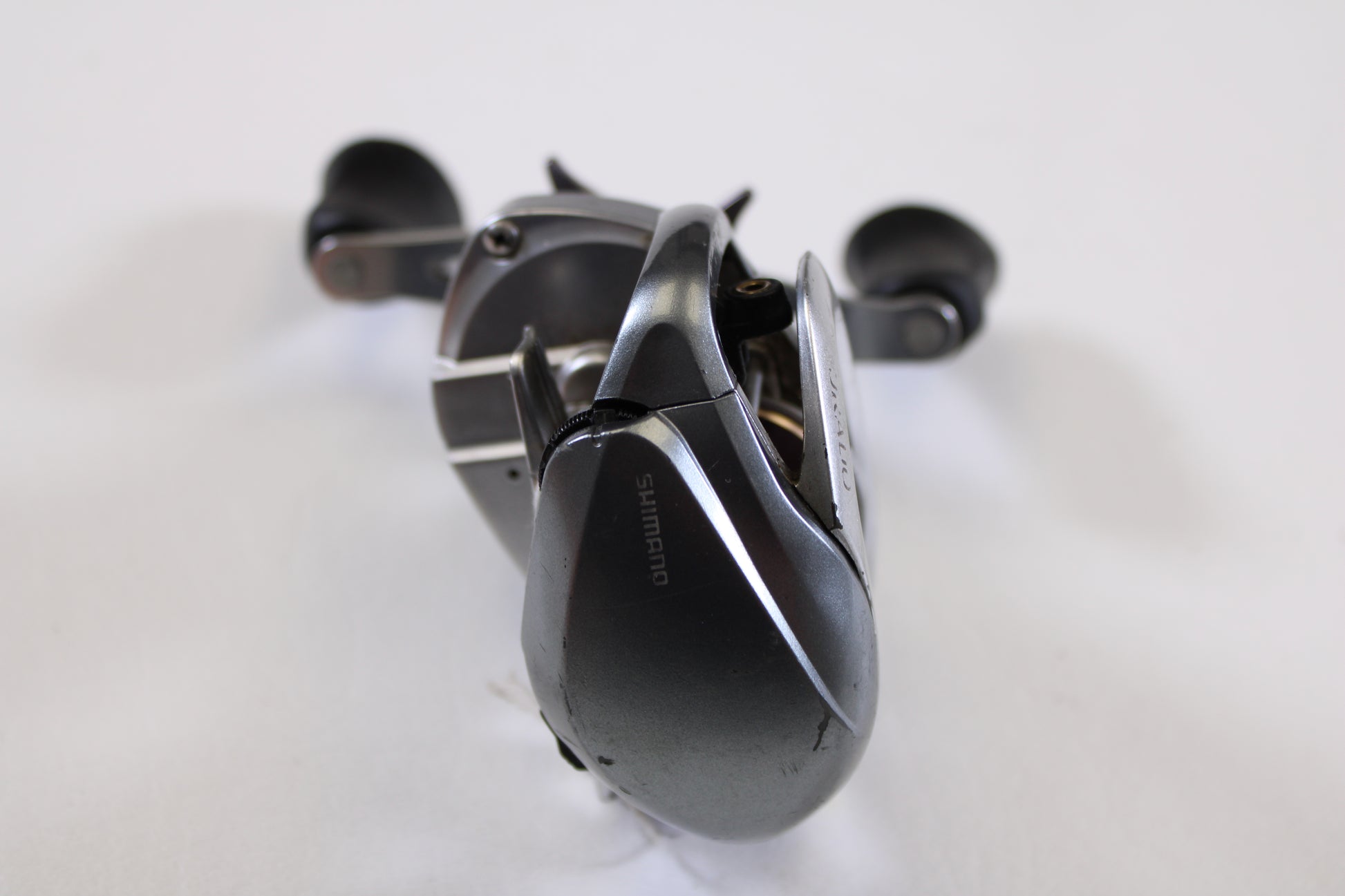 A close-up of a Shimano Curado I CU200I 6.3:1 RH used casting reel in good condition, shown in metallic grey with handle and spool on display—ideal for those trading in used gear or earning store credit.