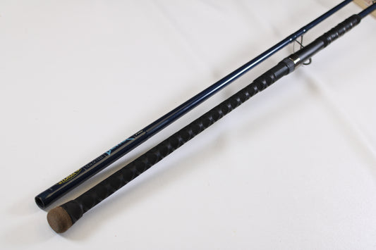 A close-up of two fishing rod handles on a white surface, including a St. Croix Seage SES90MMF2 9'0" Medium 2 Piece Used Spinning Rod—excellent condition, ideal for exchange in the Rod and Reel Trade-In Program to earn store credit.