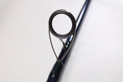 Close-up of a guide ring on a St. Croix Seage SES90MMF2 9'0" Medium 2 Piece Used Spinning Rod (Excellent Condition), available through our Rod and Reel Trade-In Program for store credit. Plain light background.