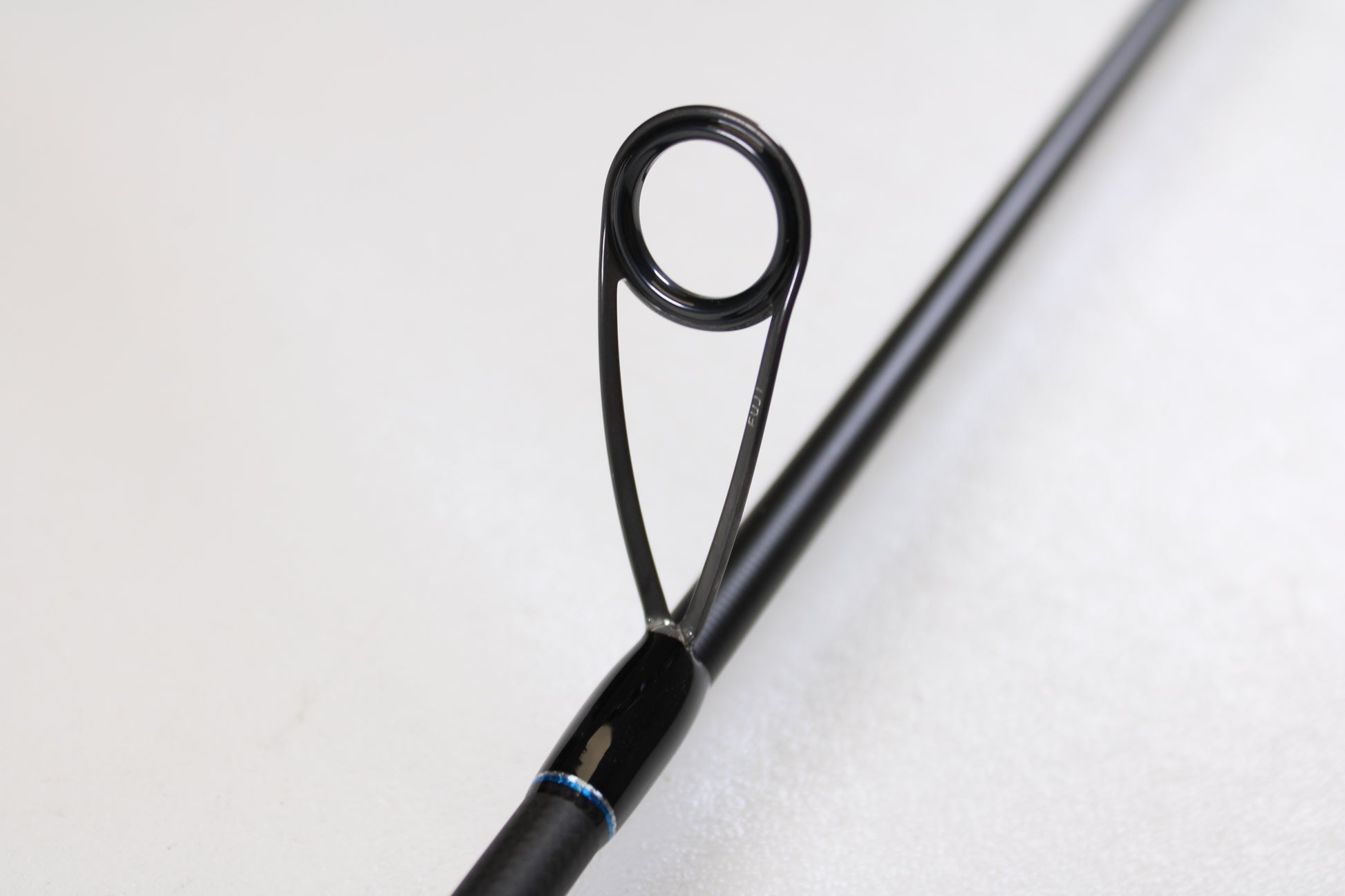 Close-up of the ODM Rods Genesis Inshore BXGX-701LS 7'0" Light—Used Spinning Rod in excellent condition. Features a circular metal guide ring with black supports, ideal for those exploring used gear or our rod and reel trade-in program.
