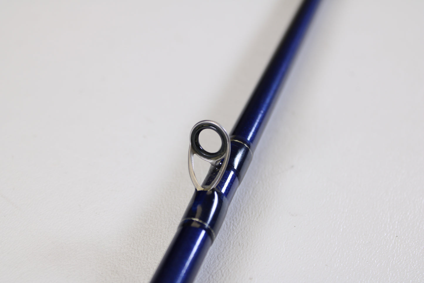 A close-up of the St. Croix Legend Tournament LBC75HMF 7'5" Heavy Used Casting Rod in excellent condition highlights a line guide against a white background—ideal for those looking to trade in used gear for store credit.