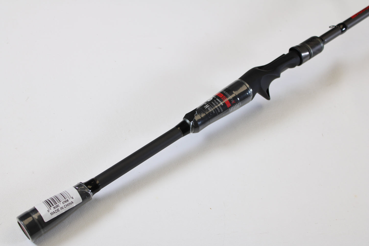 A close-up of an Abu Garcia Fantasista FNXC73-7 7'3" Heavy used casting rod in excellent condition, featuring a trigger grip handle and barcode sticker—ideal for use with store credit or trade-in programs. Set against a plain white background.