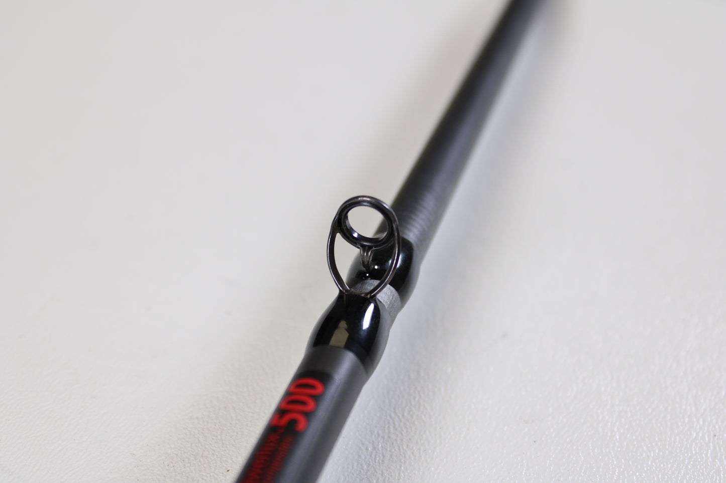Close-up of the Abu Garcia Fantasista FNXC73-7 7'3" Heavy Used Casting Rod in excellent condition, showing a guide ring and red text—ideal for those exploring our Rod and Reel Trade-In Program for used Abu Garcia gear.