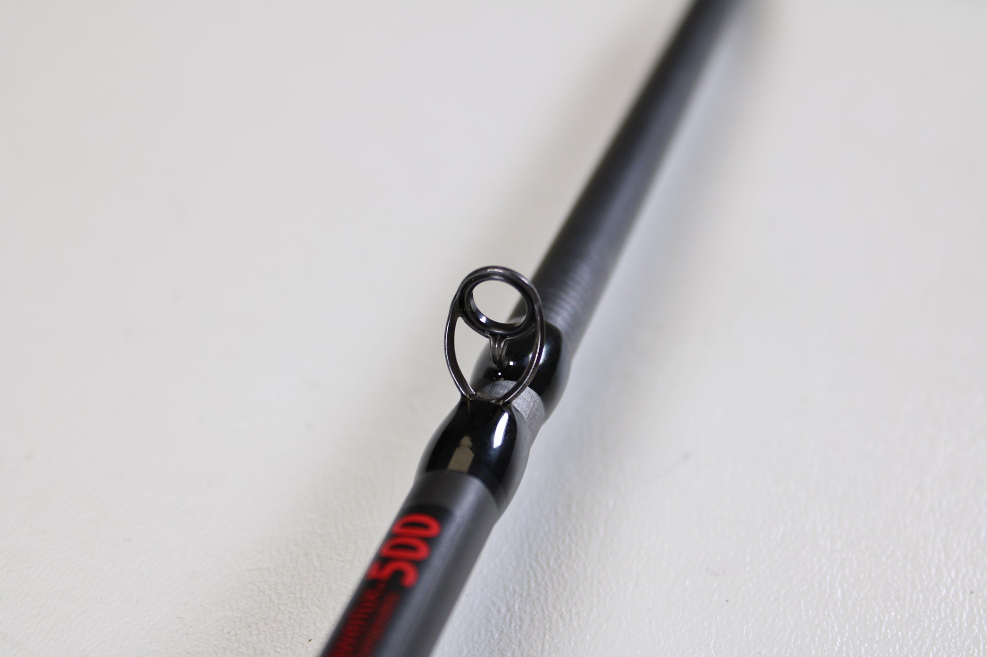Close-up of the Abu Garcia Fantasista FNXC73-7 7'3" Heavy Used Casting Rod in excellent condition, showing a guide ring and red text—ideal for those exploring our Rod and Reel Trade-In Program for used Abu Garcia gear.