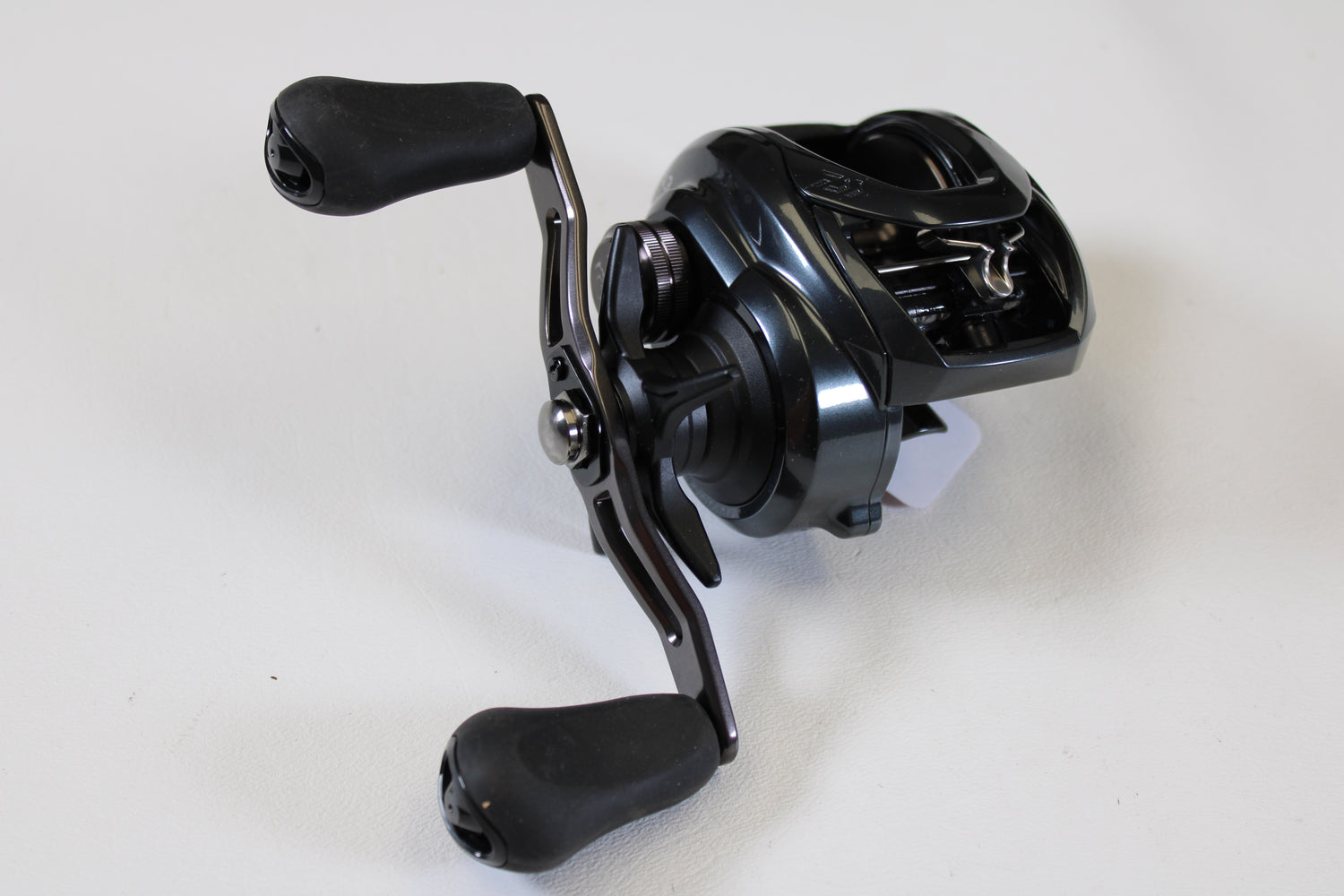 A close-up of a Daiwa Tatula 300 TTU300P 5.3:1 RH used casting reel in excellent condition with two ergonomic handles—ideal for upgrading through our rod and reel trade-in program.