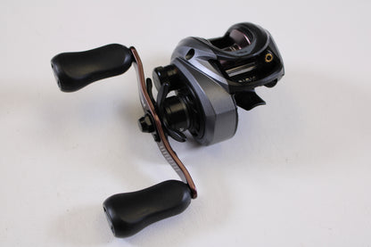 A close-up of an Abu Garcia Revo SX REVO5SXHSLP 7.3:1 RH used baitcasting reel in excellent condition, with black and silver finish and two black handles, photographed on a plain white background—great for reel trade-in or buying quality gear.