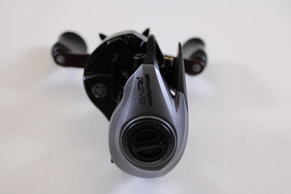 A close-up of an Abu Garcia Revo SX REVO5SXHSLP 7.3:1 RH used casting reel in excellent condition, featuring gray and black colors with visible adjustment dials, ideal for anyone seeking quality pre-owned fishing gear.