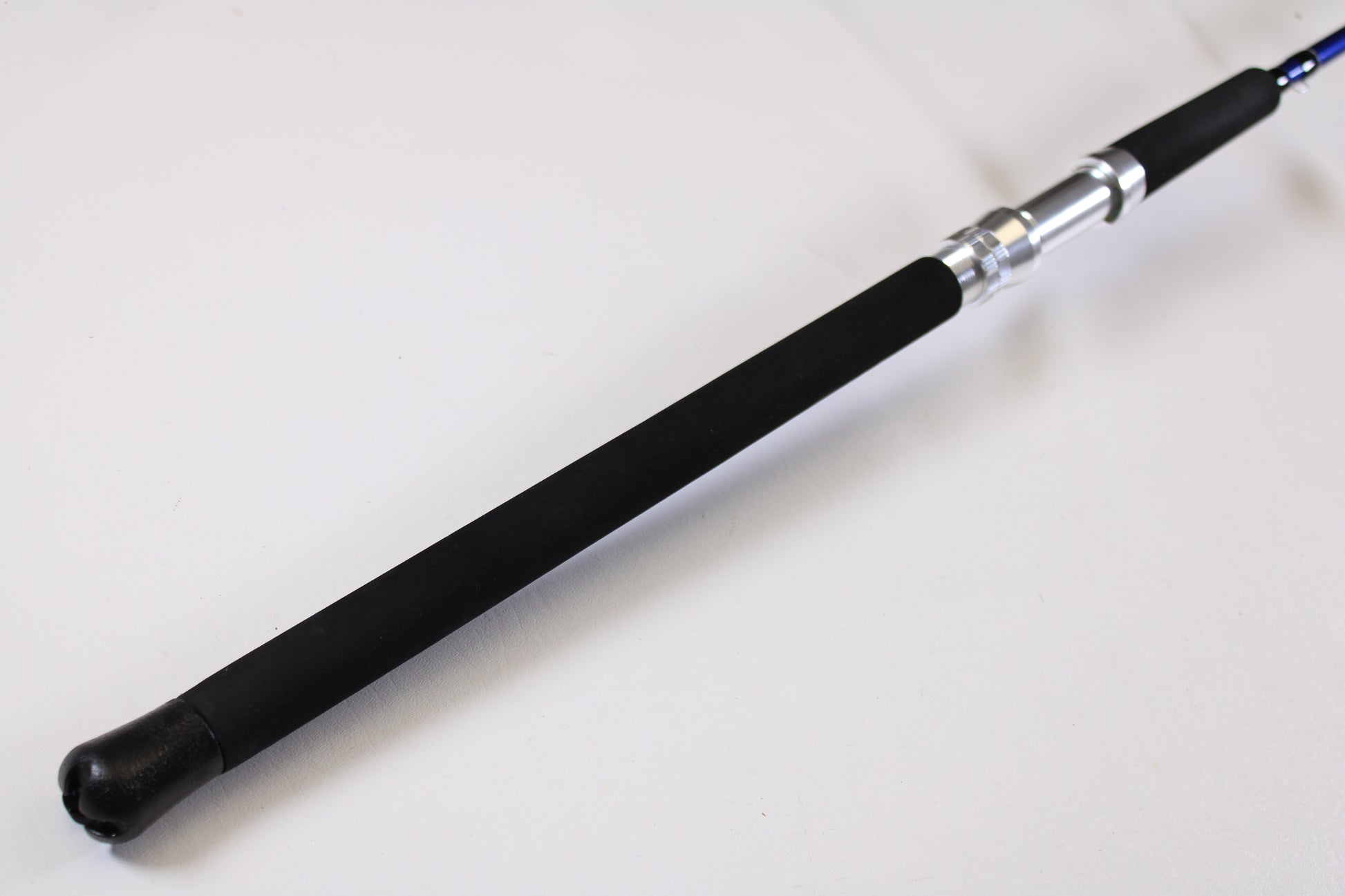 A close-up of the Shattered Cat 7'6" Heavy Casting Rod handle with a black foam grip and metallic reel seat—ideal for anglers looking to trade in or use store credit on this used Shattered Cat rod in excellent condition.