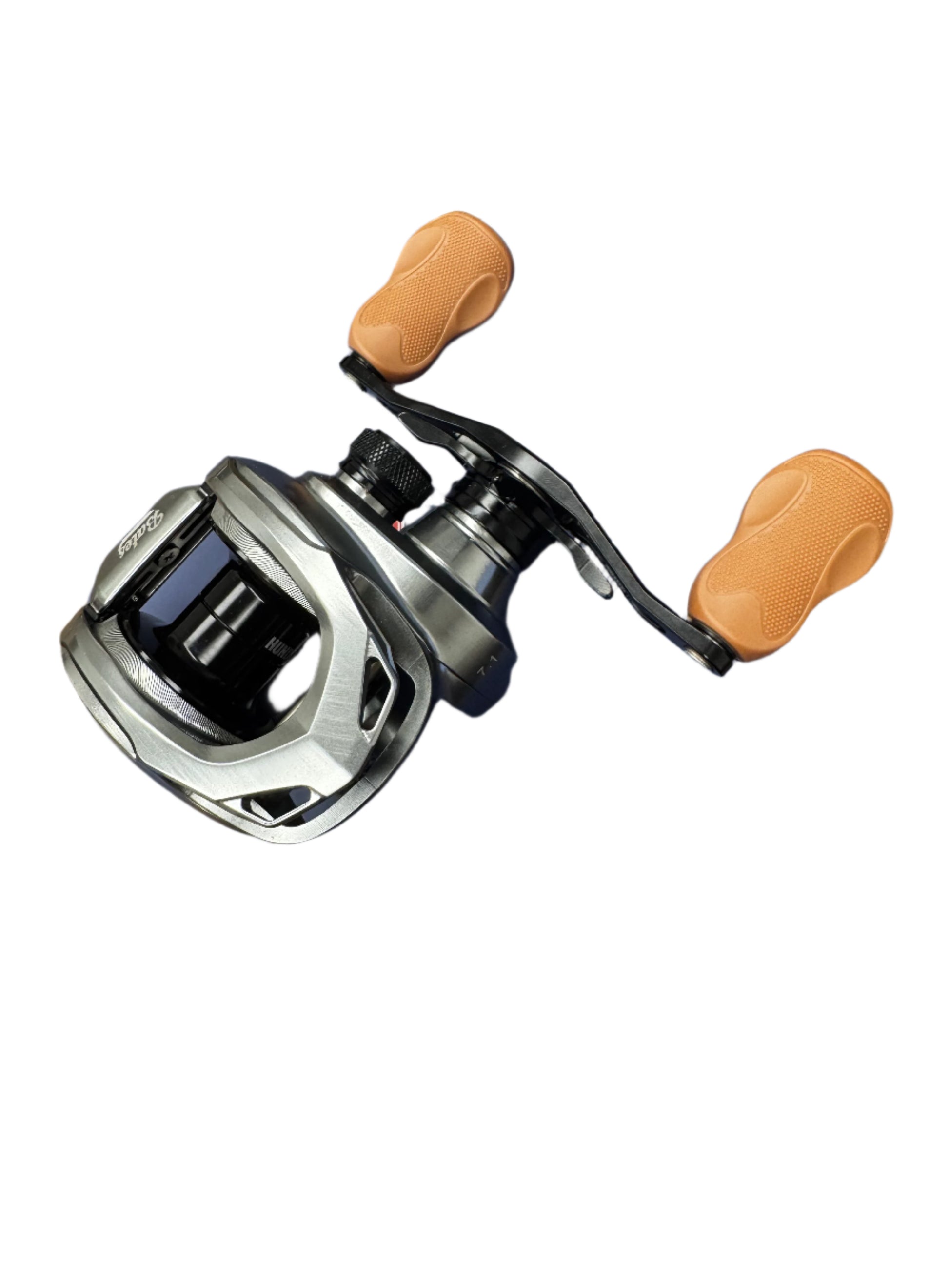 The Bates Fishing Co. Hundo 7.1:1 LH Used Casting Reel, in excellent condition, features a sleek silver and black design with two tan textured handles—ideal for bargain hunters or those using our Rod and Reel Trade-In program.