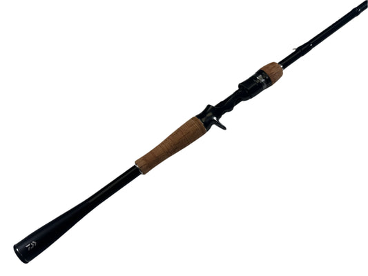 The Daiwa Zillion ZLON721MFB 7'2" Medium used casting rod, in excellent condition, is exhibited against a white backdrop. With a sleek black design and cork handle, this model has an ergonomic trigger grip reel seat and is part of our Rod and Reel Trade-In Program for potential store credit benefits.